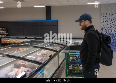 Ein Einkäufer in einem spanischen Supermarkt, der gefrorene Meeresfrüchte aus Fisch und Meeresfrüchten sowie gesunde Speisen auswählt. Stockfoto