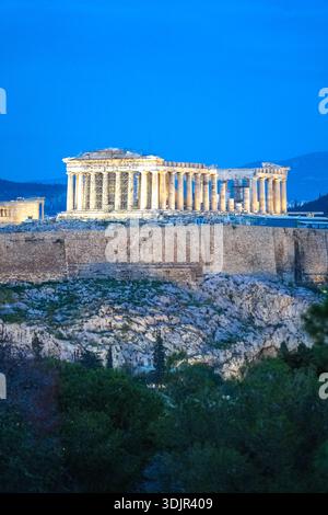 Akropolis von Athen, Parthenon. Blick vom Philopappos Hill während der blauen Stunde. Ikonischer dorischer Tempel in Athen, Griechenland, beleuchtet in der Dämmerung. Stockfoto