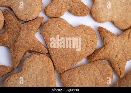 Herzförmige Ingwerkekse, die an Romantik erinnern, sanfte Goldbrauntöne, ungleichmäßige Kanten und Krume-Details, intime Dessert-Stimmung für Paare und Dattelabend Stockfoto