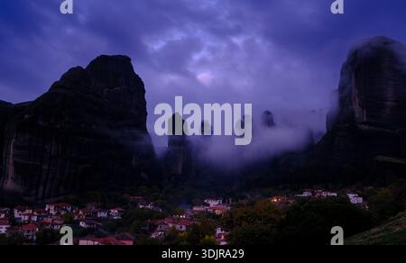 Das Dorf Kastraki unter den hoch aufragenden Meteora-Felsformationen, umgeben von dramatischen Wolken und Abendnebel, Thessalien, Griechenland Stockfoto