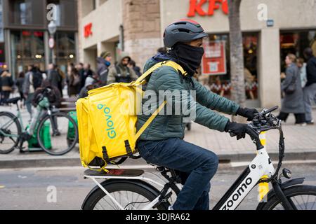 Barcelona, Spanien. Januar 2026. Ein Migrant arbeitet als Fahrer für die Lieferfirma Glovo im Stadtzentrum. Die spanische Regierung unter der Leitung von Premierminister Pedro Sánchez genehmigte eine außerordentliche Regularisierung, die rund 500.000 Migranten ohne Papiere legale Aufenthaltsrechte und Arbeitsrechte gewährte - ein historischer Schritt, der auf Inklusion, Menschenrechte und wirtschaftliche Integration abzielte. (Foto: Davide Bonaldo/SIPA USA) Credit: SIPA USA/Alamy Live News Stockfoto