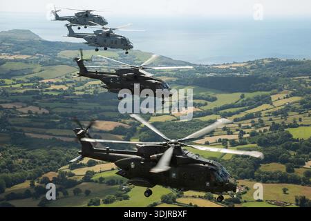 In einer Luft-Luft-Formationsansicht beim Royal Navy International Air Day bei RNAS Yeovilton 2019 sind die Hubschrauber AugustaWestland AW101 Merlin Mk4/HC4 und EHI EH101‑111 Merlin HM2 mit eingelegtem Fahrwerk dargestellt. Der AW101 ist ein Mehrzweckhubschrauber mit mittlerem Hub und drei Turbowellen-Triebwerken, und der HM2 ist ein Mehrzweckhubschrauber, der für den Einsatz auf Seefahrtpatrouille und U-Boot konfiguriert ist. Stockfoto
