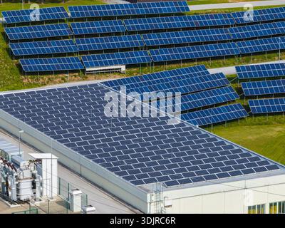 Die Drohne erfasst Solarpaneele, die auf dem Dach des Gebäudes installiert sind, und landet bei Tageslicht an einem Industriestandort. Stockfoto