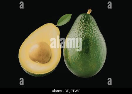 Ein Bild mit zwei Avocados, von denen einer zur Hälfte gedreht ist, um das cremige Interieur zu zeigen. Die Avocados stehen vor einem schwarzen Hintergrund. Stockfoto