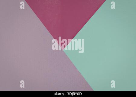 Ein Nahbild eines geometrischen Musters mit drei unterschiedlichen Farbblöcken in Rosa, Magenta und Mintgrün. Stockfoto