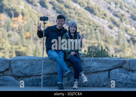 Ein Paar macht ein Selfie bei einem Aussichtspunkt im Yosemite National Park, Kalifornien, USA. Stockfoto