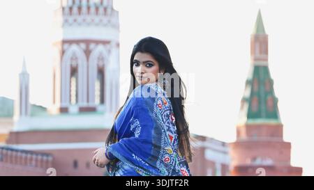 Eine junge Frau posiert draußen, blickt in die Kamera, trägt einen blauen Saree in Moskau Stockfoto