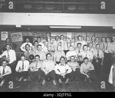 Eine Gruppe enthusiastischer Bowler in Detroit posiert, ein Mann zeigt seinen Ball mit 300 Punkten. In den 1940er Jahren war Bowling sehr beliebt und diente vielen Amerikanern als bevorzugter Freizeitbeschäftigung, vor allem als Möglichkeit, vom Krieg in Europa abzulenken. Die Teilnahme an der Sportart nahm deutlich zu, viele Bowlingbahnen blühten und Ligen bildeten sich in dieser Zeit im ganzen Land. Sogar die Detroit Press bot eine Bowlingschule an. Stockfoto