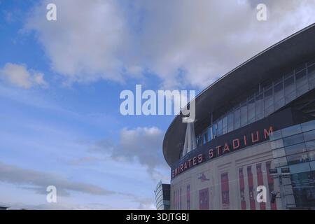 Arsenals Emirates Stadium, London, 2026 Außenfassade, die das beeindruckende moderne Design des Stadions, die Plätze mit Faneingang an sonnigem Tag und den blauen Himmel 2025 einfängt Stockfoto