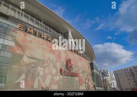Arsenals Emirates Stadium, London, 2026 Außenfassade, die das beeindruckende moderne Design des Stadions, die Plätze mit Faneingang an sonnigem Tag und den blauen Himmel 2025 einfängt Stockfoto