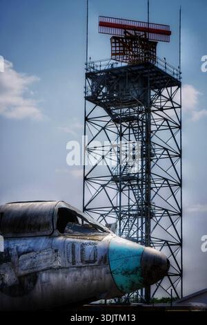 Verwitterte Flugzeuge unter dem Radarturm auf dem Flugplatz Stockfoto