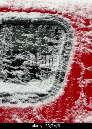 Detail eines roten Autos mit Schnee Stockfoto