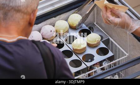 Kunde wählt aromatisierte Eiskegel von einem Straßenkühlschrank Stockfoto