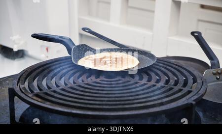 Kochen Sie Pfannkuchen auf einer warmen Grillplatte im Freien Stockfoto