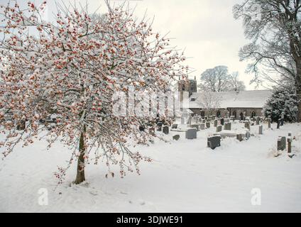 Die verschneite Yorkshire Dales-Szene zeigt die Dorfkirche, die St. Marys heißt. Gelegen in Long Preston, North Yorkshire. Stockfoto