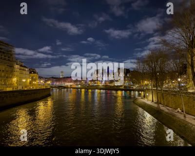 Nachtaufnahme der seine in Paris, Frankreich, mit dem beleuchteten Hôtel de Ville (Pariser Rathaus) auf der Île de la Cité - Paris Frankreich Stockfoto