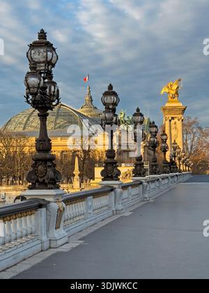 Lampenpfosten auf der Brücke Pont Alexandre III in Paris, mit Blick auf den Grand Palais im Hintergrund - Frankreich Stockfoto