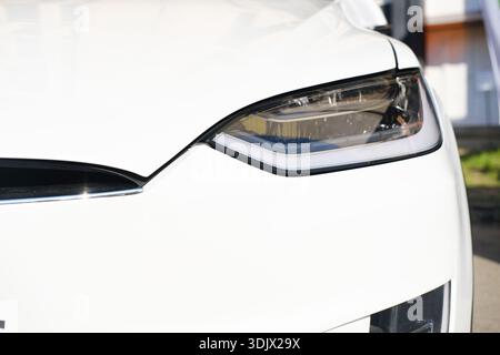 Minsk, Weißrussland - 10. April 2025: Nahaufnahme des weißen Scheinwerfers für Elektrofahrzeuge, der fortschrittliches Design und Technologie für moderne Automobile unterstreicht Stockfoto