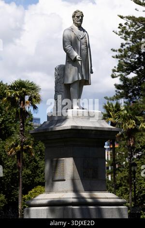 Statue von Prinz Albert auf einem Steinsockel im Albert Park, Auckland, umgeben von Palmen und Grün unter teilweise bewölktem Himmel. Stockfoto