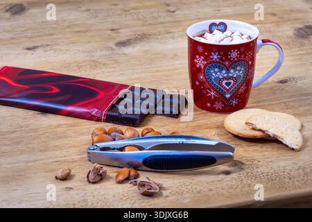 Heiße Schokolade, Kekse und Haselnüsse auf einem Tisch Stockfoto