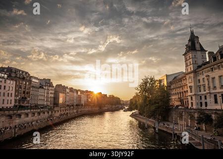 PARIS, FRANKREICH - 22. JUNI 2025: Panoramablick auf die seine und die historischen Gebäude der Ile de la Cite in Paris bei Sonnenuntergang. Das goldene Licht Stockfoto