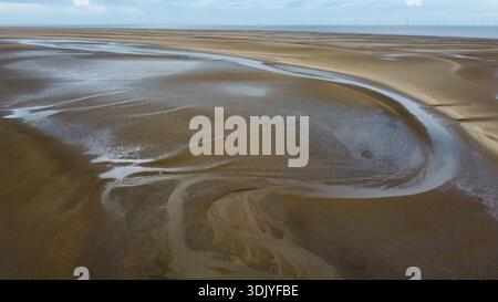 Luftaufnahme von schwungvollen Gezeitenkanälen und abstrakten Wasserentwässerungsmustern auf Sand Stockfoto