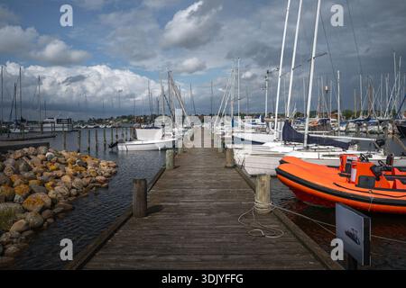 Ein hölzerner Pier führt die Segelboote in den ruhigen Gewässern des Roskilde Harbour. Stockfoto