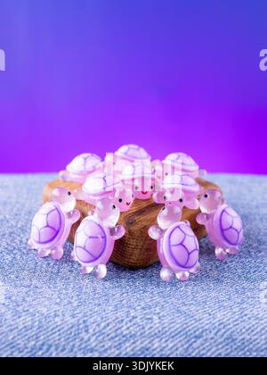 Eine Nahaufnahme einer Reihe violetter, verspielter Schildkröten-Innenfiguren, die auf einer Holzbühne angeordnet sind Stockfoto