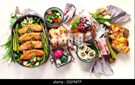 Im Ofen gebratener Lachs mit grünen Bohnen und Spargel zum Osterbrunch oder Abendessen auf hellem Hintergrund. Draufsicht. Stockfoto