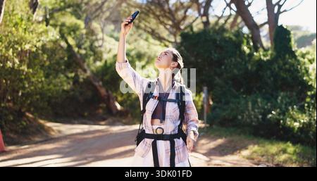 Frau, Telefon und Wandern im Wald mit verlorenem Signal, Suche und Stress nach Ort auf Abenteuer. Person, Smartphone und digitale Karte für den Trail Stockfoto