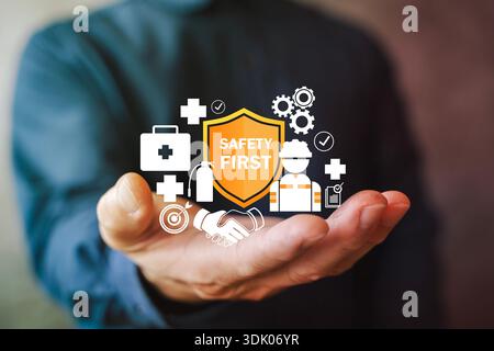 Handpräsentation des Schutzschildes mit Symbolen für erste Hilfe, Arbeiter, Zahnräder und Checkliste. Konzept der Arbeitssicherheit, Arbeitsmedizin, Complianc Stockfoto