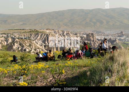 Kappadokien, Türkei - 18. Mai 2025: Gruppe von Wanderern, die eine Picknickpause auf einem Hügel mit Blick auf das Tal von Kappadokien machen Stockfoto