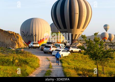 Kappadokien, Türkei - 18. Mai 2025: Autos und Zuschauer versammeln sich auf einer Feldstraße, um Heißluftballons zu beobachten Stockfoto