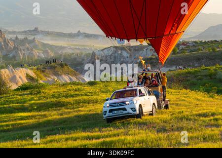 Kappadokien, Türkei - 18. Mai 2025: Touristen in einem Heißluftballonkorb auf einem Pickup-Anhänger nach der Landung Stockfoto