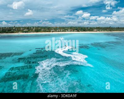 Aus der Vogelperspektive auf Jetskis über dem flachen türkisfarbenen Meer mit Riff Stockfoto