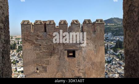Nahaufnahme der Festungsmauern von Torre del Homenaje mit dem Bezirk Albaicin im Hintergrund. Alhambra de Granad, UNESCO-Stätte, Granada, Spanien. Steinrahmen. Stockfoto