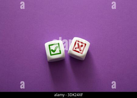 Zwei weiße Blöcke mit grünem Häkchen und rotem Kreuz auf violettem Hintergrund Stockfoto