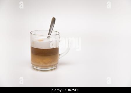 Cappuccino in einer Glasschale mit Milchschaum auf weißem Hintergrund Stockfoto