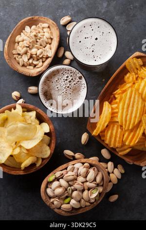 Lagerbier und Snacks auf Tisch aus Stein. Nüsse, Chips. Ansicht von oben Stockfoto