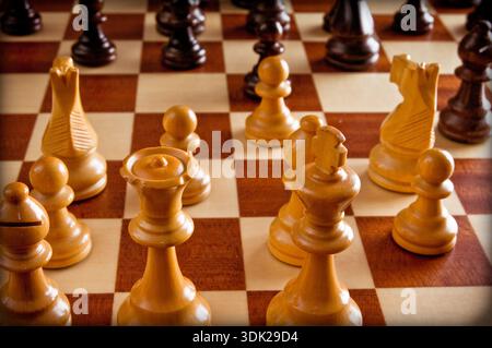 Hölzerne Schachfiguren auf einem Schachbrett, die Strategie, Planung und Entscheidungsfindung in einem Wettkampf darstellen Stockfoto