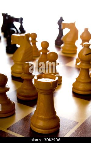 Hölzerne Schachfiguren auf einem Schachbrett, die Strategie, Planung und Entscheidungsfindung in einem Wettkampf darstellen Stockfoto