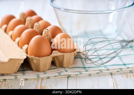 Frühstückszubereitung. Omelette-Rezept. Geschlagene rohe Eier in einer Schüssel mit Schneebesen. Stockfoto