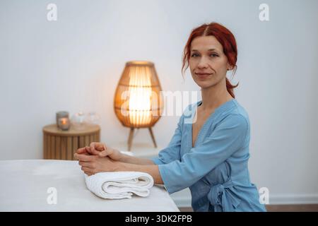 Frische Handtücher. Dermatologe, auch als Kosmetikerin und Kosmetikerin ausgebildet, posiert für ein Porträt im Büro eines Schönheitssalons. Stockfoto