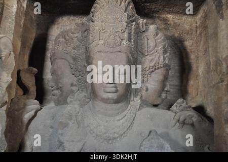 Nahaufnahme einer in Stein gehauenen hinduistischen Gottheit Figur im antiken Höhlentempel in Indien Stockfoto