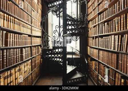 Alte Bibliothek mit Wendeltreppe und antiken Büchern. Stockfoto