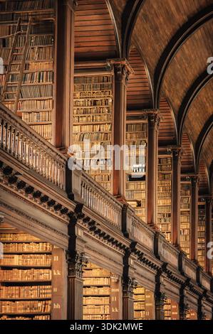 Alte Bibliothek mit kunstvoller Holzarchitektur und endlosen Bücherregalen Stockfoto