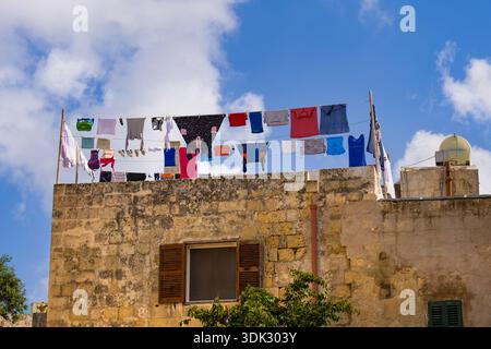 Trocknende Kleidung hängt an Wäscheleinen auf einem Dach eines traditionellen Steinhauses in der Stadt Mdina, Malta. Stockfoto