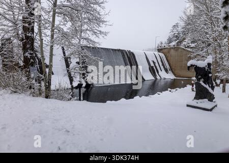 Evergreen Lake ist während eines starken Winterschneefalls in Evergreen, Colorado, mit frischem Schnee bedeckt. Schneebedeckte Bäume umgeben den gefrorenen See im Winter Stockfoto