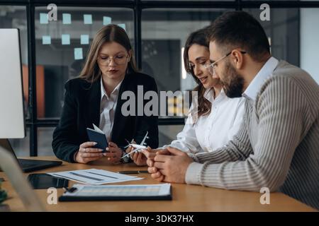 Ich schaue mir ein kleines Spielzeugflugzeug an. Geschäftsleute arbeiten im Büro. Stockfoto