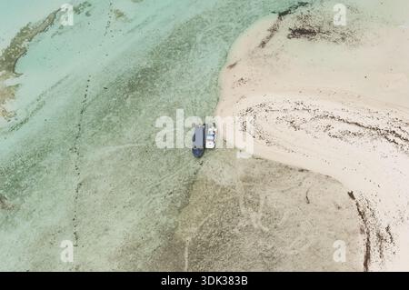 Aus der Vogelperspektive auf Boote, die am Ufer liegen, wo das türkisfarbene Wasser auf den unberührten Sand trifft, Seychellen, Seychellen. Stockfoto